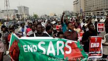 People protest at Lekki Toll plaza in Lagos, Nigeria, Wednesday, Oct. 20, 2021. Nigerian police officers fired tear gas at protesters in Lagos, the country's largest city, as they tried to disperse hundreds of people demonstrating against police brutality on Wednesday. One year ago, thousands marched in Nigeria for the #EndSARS movement to protest the activities of the now-disbanded Special Anti-Robbery Squad, a unit accused of police brutality. (AP Photo/Sunday Alamba)