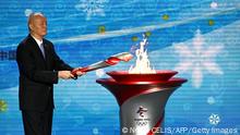 TOPSHOT - Communist Party Secretary of Beijing, Cai Qi, lights the cauldron during the Olympic flame welcoming ceremony ahead of the Beijing 2022 Winter Olympics, in the lobby of the Olympic Tower in Beijing on October 20, 2021. (Photo by Noel Celis / AFP) (Photo by NOEL CELIS/AFP via Getty Images)