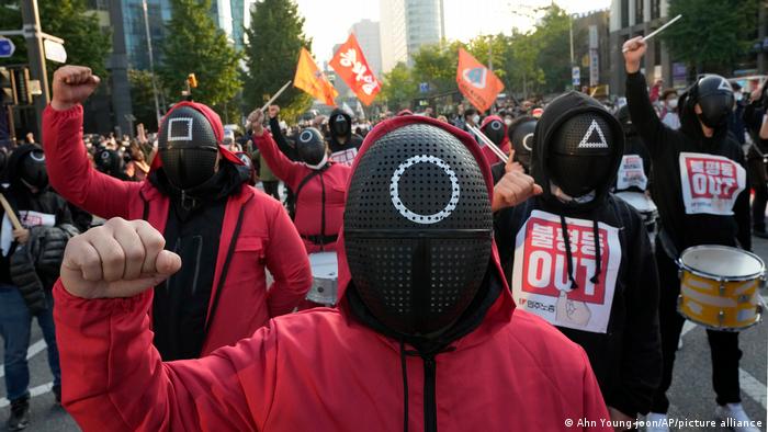 Members of the South Korean Confederation of Trade Unions wearing masks and costumes inspired by Netflix's original Korean series Squid Game.