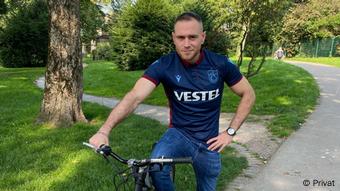 Adnan Arslan auf dem Fahrrad in einer städtischen Grünanlage