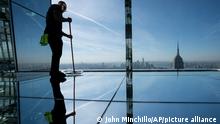 A worker cleans the mirrored portion of the 91st floor during the grand opening of SUMMIT One Vanderbilt, a skyscraper observatory on Manhattan's iconic 42nd Street, Thursday, Oct. 21, 2021, in New York. (AP Photo/John Minchillo)