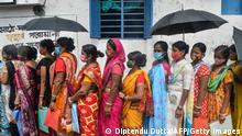 TOPSHOT - Women stand in a queue as they wait to receive a dose of the Covishield vaccine against the Covid-19 coronavirus at a primary health centre in Siliguri on August 2, 2021. (Photo by Diptendu DUTTA / AFP) (Photo by DIPTENDU DUTTA/AFP via Getty Images)