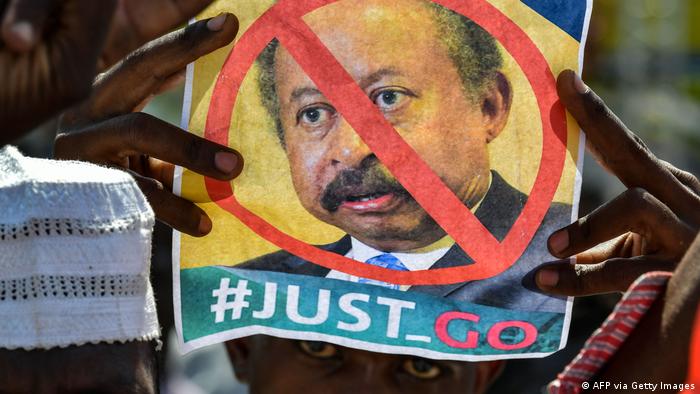 A Sudanese demonstrator raises a picture bearing a crossed out face of Prime Minister Abdalla Hamdok
