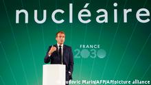 French President Emmanuel Macron speaks in front of a sign that reads nuclear in French