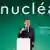 French President Emmanuel Macron speaks in front of a sign that reads "nuclear" in French