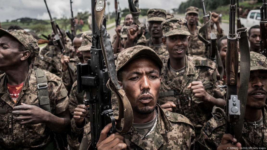  Ethiopian National Defence Forces (ENDF) soldiers brandish weapons as they shout slogans.