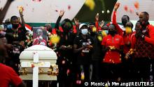 Kenyan athletes and mourners throw flowers towards the coffin in memory of long-distance runner Agnes Tirop during her funeral service at Kapnyamisa village, Nandi county, Kenya October 23, 2021. REUTERS/Monicah Mwangi