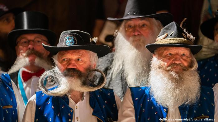 Ovo su učesnici Olimpijade brade i nemačkog prvenstva brade koje se održava u Bavarskoj. Muškarci se takmiče u nekoliko kategorija - carska, musekarska, duga... Zato verovatno ova gospoda na slici ima slične kostime, ili nošnje, a različite brade.