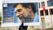 Hand holds up a poster showing head of Osman Kavala, and a quote in German by the PEN organization Hand holds up a poster showing head of Osman Kavala, and a quote in German by the PEN organization