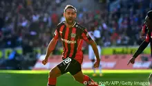 Leverkusen's German midfielder Karim Bellarabi celebrates scoring the 0-2 goal with his teammates during the German first division Bundesliga football match 1 FC Cologne v Bayer 04 Leverkusen, in Cologne, western Germany, on October 24, 2021. - DFL REGULATIONS PROHIBIT ANY USE OF PHOTOGRAPHS AS IMAGE SEQUENCES AND/OR QUASI-VIDEO (Photo by UWE KRAFT / AFP) / DFL REGULATIONS PROHIBIT ANY USE OF PHOTOGRAPHS AS IMAGE SEQUENCES AND/OR QUASI-VIDEO (Photo by UWE KRAFT/AFP via Getty Images)