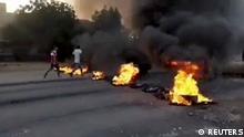 People walk past burning objects lying on the streets of Kartoum, Sudan, amid reports of a coup, October 25, 2021, in this still image from video obtained via social media. RASD SUDAN NETWORK via REUTERS ATTENTION EDITORS - THIS IMAGE HAS BEEN SUPPLIED BY A THIRD PARTY. MANDATORY CREDIT. NO RESALES. NO ARCHIVES.