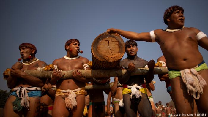 Indígenas carregando troncos 