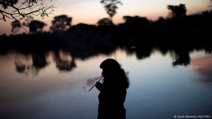 Silhueta de mulher indígena fumando cachimbo 