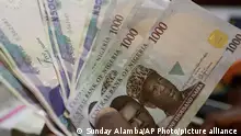 FILE - In this Tuesday, Oct. 20, 2015, file photo, a money changer counts Nigerian naira currency at a bureau de change, in Lagos, Nigeria. These are sobering times for Africa¿s two biggest oil producers. Oil previously provided 80 percent of government revenue in Nigeria and 70 percent in Angola. Nigeria¿s 2016 budget is double that of 2015 and based on $38 oil, so the government plans to borrow heavily. Angola¿s budget is based on a price of $40, down from an earlier benchmark of $81. Both countries¿ currencies have plunged against the dollar. (AP Photo/Sunday Alamba, File)