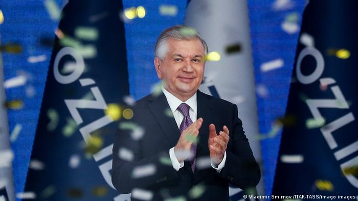 Der Präsident von Usbekistan, Schawkat Mirsijojew, steht lächelnd in einem Konfetti-Regen und klatscht