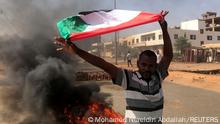 A protester waves a flag during what the information ministry calls a military coup in Khartoum, Sudan, October 25, 2021. REUTERS/Mohamed Nureldin Abdallah
