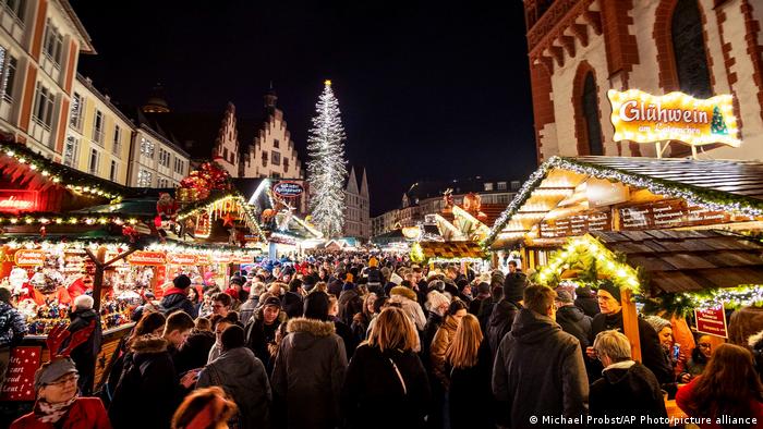 People milling around the stalls at night at the Frankfurt Christmas Market
