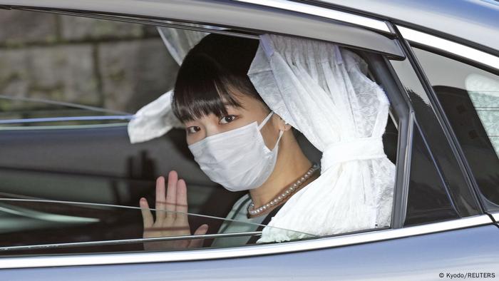Japan's Princess Mako waves from inside a car as she leaves her home for her marriage in Akasaka Estate in Tokyo