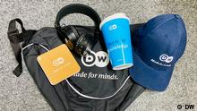 DW Sling Pack, Cap, headphone and To Go Cup.