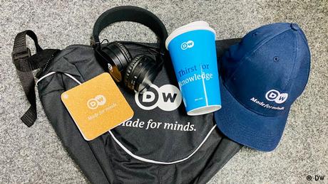 DW Sling Pack, Cap, headphone and To Go Cup.
