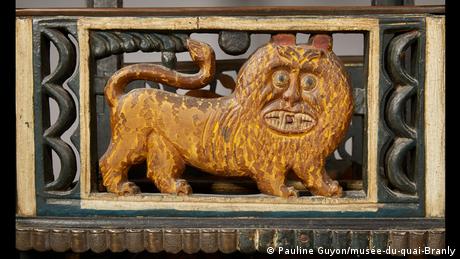 Détail d'une chaise en bois avec une sculpture d'un lion. 