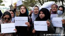 Women hold placards during a protest in Kabul on October 26, 2021, calling for the international community to speak out in support of Afghans living under Taliban rule. (Photo by James EDGAR / AFP)