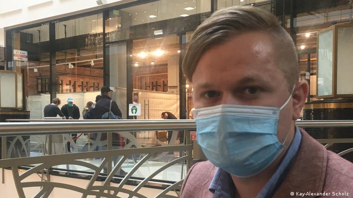 Konstantin Keesmann portant un masque bleu dans le centre commercial Alexa