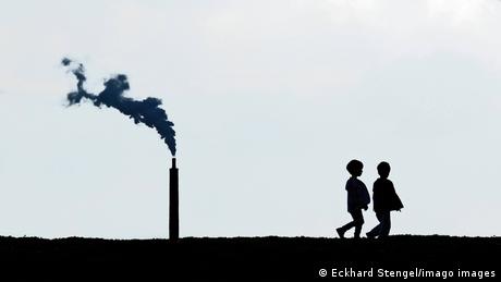 صورة رمزية لأطفال بجانب مدخنة أحد المصانع 