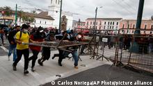 Protesters remove a crowd control barricade near the government palace on the first day of a general, nation-wide strike to decry the rise in gas prices and the policies of Ecuador's President Guillermo Lasso, in Quito, Ecuador, Tuesday, Oct. 26, 2021. (AP Photo/Carlos Noriega)
