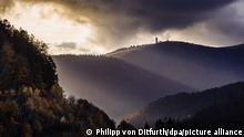 26.10.2021, Die Sonnenstrahlen der tiefstehenden Herbstsonne streifen den Feldbergturm auf dem Gipfel des Feldbergs und die herbstlich-bunt gefärbten Wälder des Schwarzwaldes.