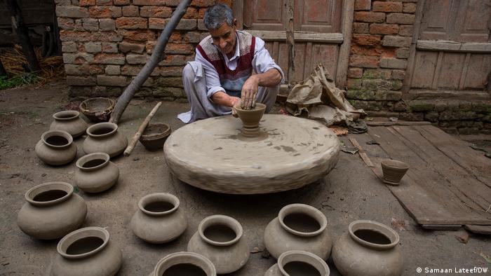 Muhammad Jamal Kumhar, 70, molds the clay into a pot at Larm-Ganjipora village in south Kashmir's Anantnag district