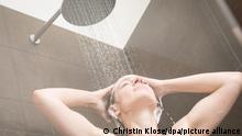 ILLUSTRATION - Eine junge Frau steht am 26.05.2020 in Wittenberge in einer Wohnung unter der Dusche und waescht sich die Haare (gestellte Szene). Foto: Christin Klose || Modellfreigabe vorhanden