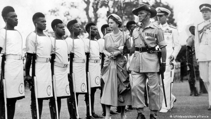 Queen Elizabeth II walks next to Canberra Marine Soldiers from Papua New Guinea in 1954.