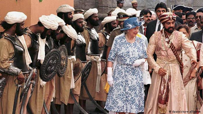 Queen Elizabeth II walks with Indian actor Kamal Haasan on a film set.