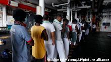African migrants wait in line to receive meals abroad the Geo Barents vessel after they were rescued from the Mediterranean Sea off Libya, Monday, Sept. 27, 2021. Migrants say that they were tortured and their families extorted for ransoms in Libya’s detention centers. (AP Photo/Ahmed Hatem)