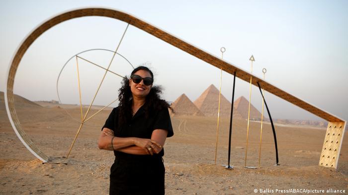 Die in Los Angeles lebende ägyptische Künstlerin Sherin Guirguis steht vor ihrem Werk „Here I Have Returned“, einer abstrakten großen gebogenen Skulptur.