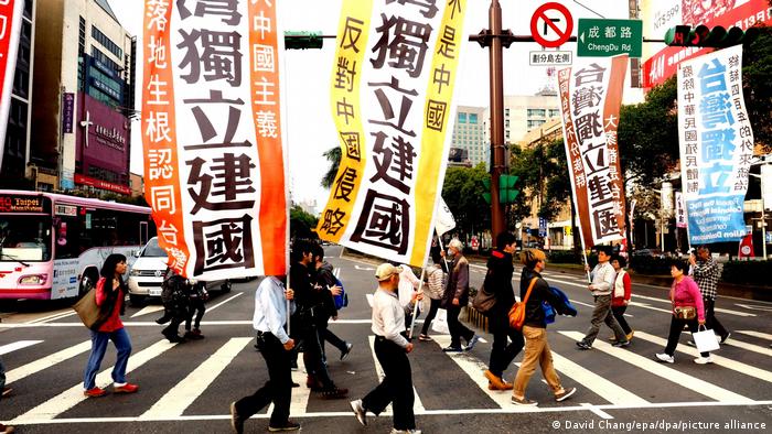 李明哲告诉DW：“中国对台湾的打压未来会无所不在，而且不是你不到中国就没有问题。”图为台独人士举旗在台北街头游行。