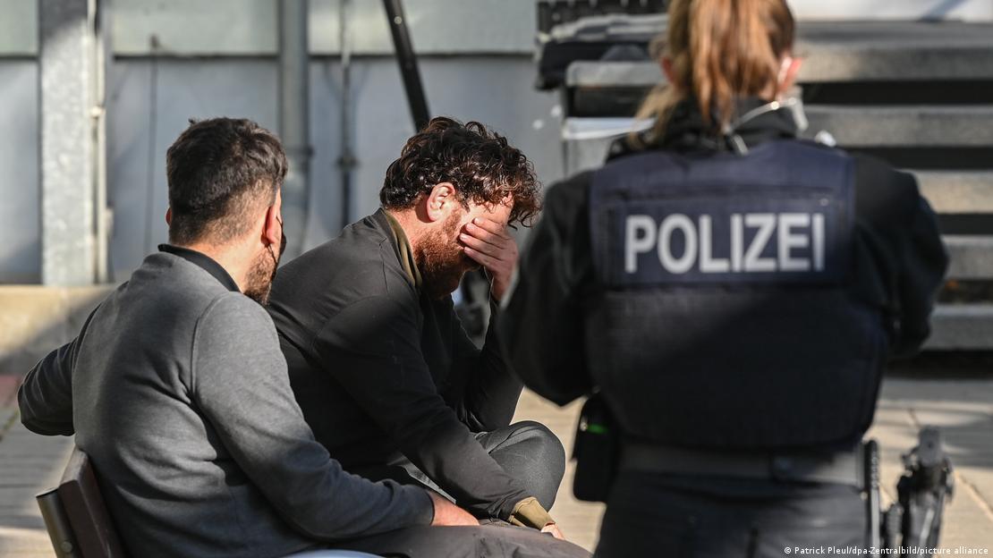 Αστυνομικός επιβλέπει δύο πρόσφυγες στα σύνορα Γερμανίας-Πολωνίας