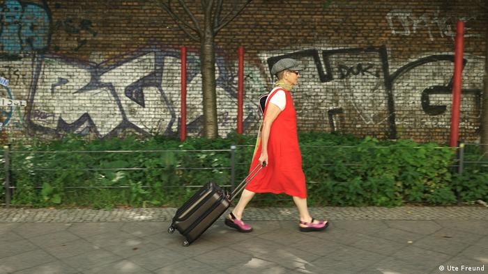 A woman wheels a suitcase