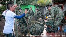 A peasant speaks with Colombian soldiers after they were released in the municipality of Tibu, Norte de Santander department, Colombia, on the border with Venezuela, on October 28, 2021. - Colombian President Ivan Duque on Thursday had urged coca growers to free 180 soldiers they had taken hostage during an anti-narcotics operation, warning of consequences if they don't. The troops were taken Tuesday while destroying plantations of the cocaine-yielding plant near the Venezuelan border. (Photo by SCHNEYDER MENDOZA / AFP) (Photo by SCHNEYDER MENDOZA/AFP via Getty Images)