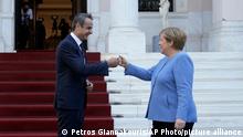 Greece's Prime Minister Kyriakos Mitsotakis, left, welcomes Germany's Chancellor Angela Merkel before their meeting at Maximos Mansion in Athens, Greece, Friday, Oct. 29, 2021. Germany's outgoing Chancellor Angela Merkel is on a two-day visit to the country whose financial crisis marked much of her tenure and Germany's relationship with Europe. (AP Photo/Petros Giannakouris)