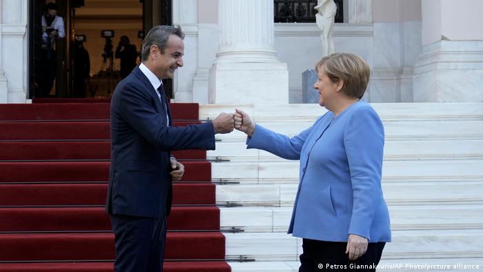 Greece's Prime Minister Kyriakos Mitsotakis, left, welcomes Germany's Chancellor Angela Merkel before their meeting at Maximos Mansion in Athens