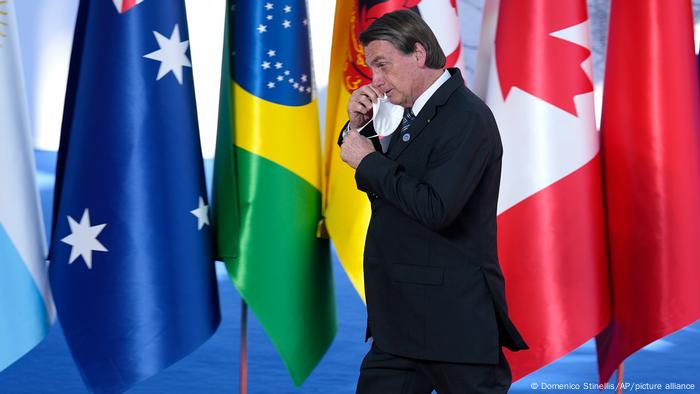 Jair Bolsonaro caminha diante de bandeiras na cúpula do G20 em Roma