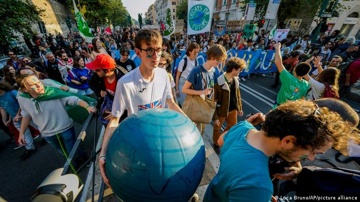 A protester marches with a makeshift planet Earth globe in Rome on October 30, 2021, the day the G20 summit begins