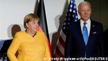 Germany's Chancellor Angela Merkel and U.S. President Joe Biden pose the media prior to a meeting during the G20 leaders' summit in Rome, Italy October 30, 2021. Kirsty Wigglesworth/Pool via REUTERS