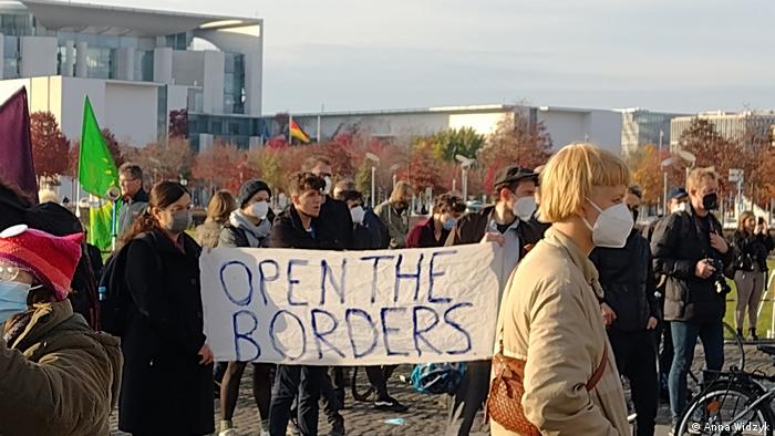 Protesters hold a banner saying 'Open the borders' at the Bundestag in Berlin, Germany