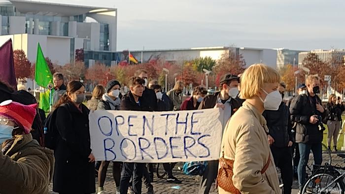 Protesters hold a banner saying 'Open the borders' at the Bundestag in Berlin, Germany