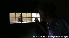 A picture taken on September 2, 2014 in the Iranian capital Tehran shows a visitor looking through the grill of a cell of the Qasr prison, a former prison hosting political prisoners that was turned into a museum in 2012. The building was built in 1790 at the time of Qajar king, Fath-ali Shah by the Russian architect Markov before it was converted into a prison in 1929. AFP PHOTO/ATTA KENARE (Photo credit should read ATTA KENARE/AFP via Getty Images)