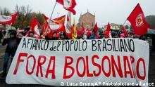 People show placards in Italian reading At the side of the Brazilian people. Bolsonaro out in Anguillara Veneta, northern Italy, Monday, Nov. 1, 2021, as they await for the Brazilian President Jair Bolsonaro to arrive in the town where his great-great-grandfather was born and where he was recently granted honorary citizenship . The decision by the mayor of Anguillara, Alessandra Buos, has sparked protests, in particular by Italian missionaries in Brazil. (AP Photo/Luca Bruno)