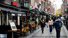 FILE PHOTO: People walk past restaurants and bars in Amsterdam, Netherlands October 14 2020. REUTERS/Piroschka van de Wouw/File Photo